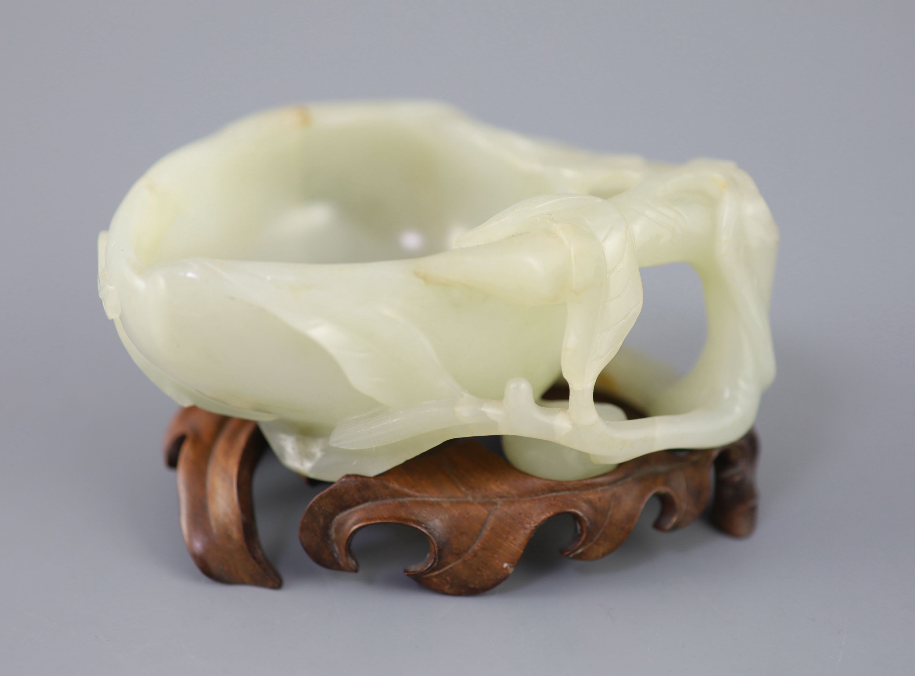 A Chinese pale celadon jade peach brush washer, 17th/18th century 11.3cm at widest point, wood stand